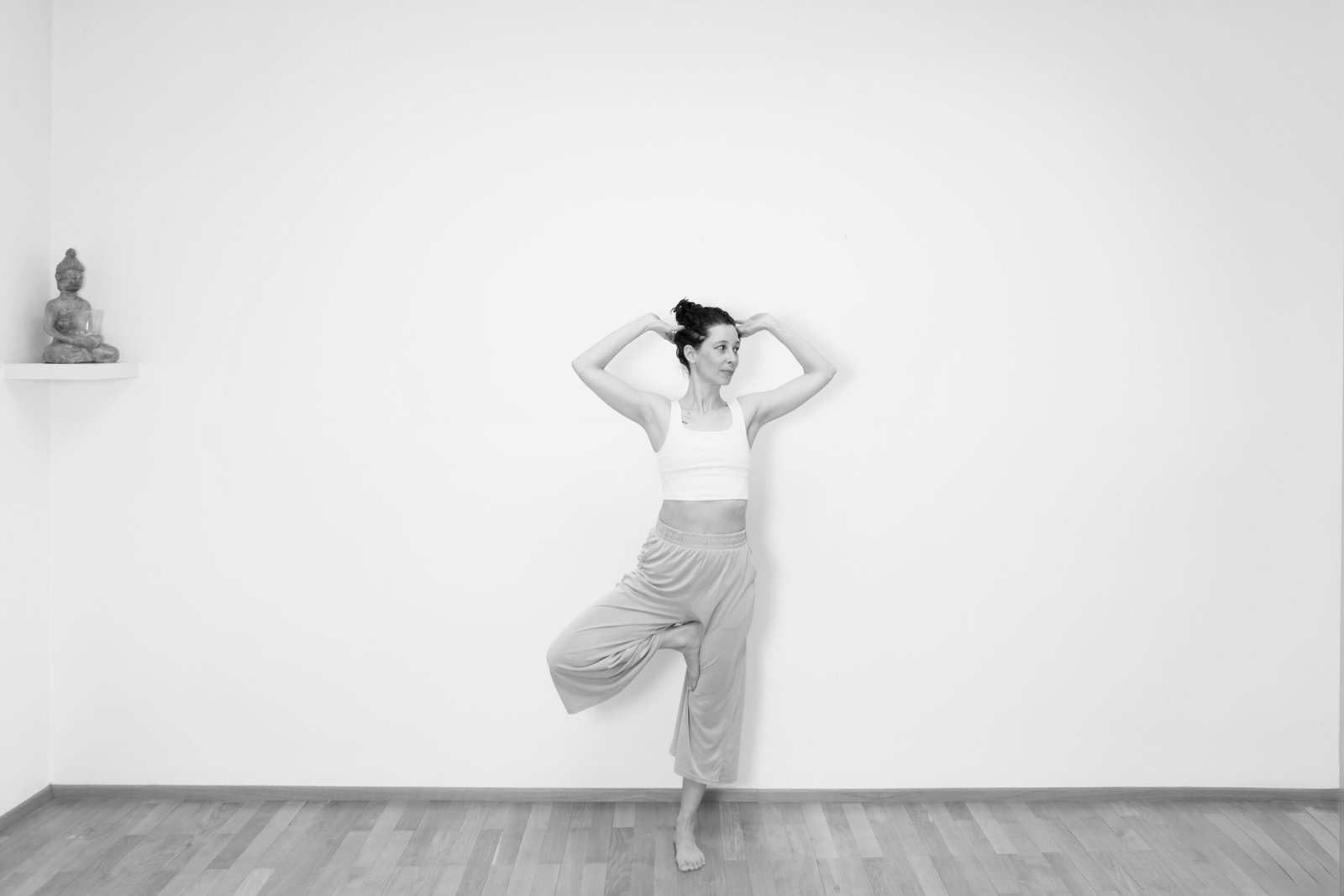 schwarzweiß foto von moinka steininger in Yogapose Baum mit Händen am Kopf