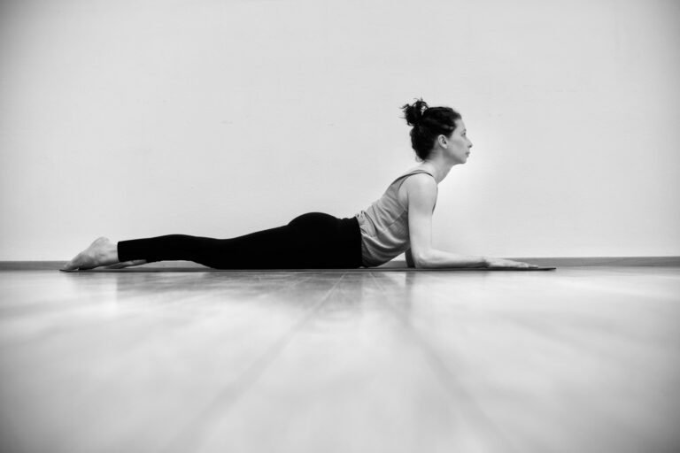 schwarz weiß fotot von liegender Frau in Yogapose Sphinx